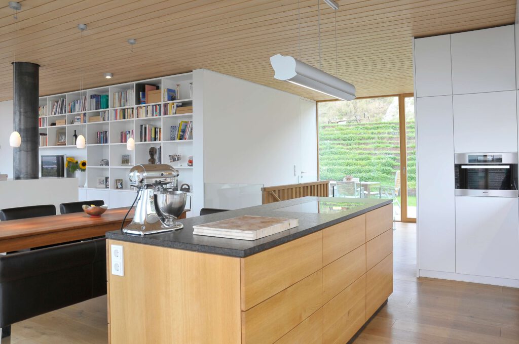 Kueche-schreiner-auf-mass-grifflos-holz-weiss-eiche-lackiert-hochschrank-modern-kochinsel-geoelt-lackiert-stein-arbeitsplatte-beleuchtet-haengelampequerholz-bensheim