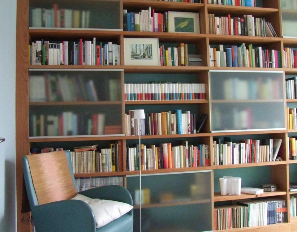 Bücherregal für den Wohnbereich in Kirsche massiv. Schiebetüren in satiniertem Glas mit Rahmen in Aluminium